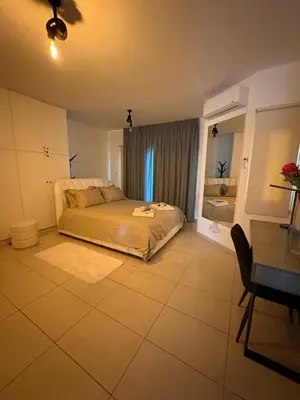 a bedroom with a bed and a table and a desk at FLH - Feel Like Home Modern 1-Bedroom Ground floor Apartment in Strovolos in Kato Lakatamia