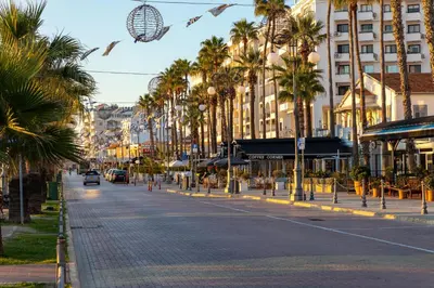 a city street with palm trees and buildings at The Colonial in Larnaka