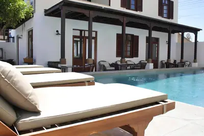 a row of lounge chairs next to a swimming pool at The Colonial in Larnaka