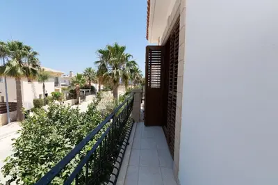 a balcony of a building with a fence and palm trees at Malama 28 Villa Ekaterina in Paralimni
