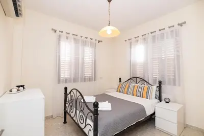 a bedroom with a bed and two windows at Malama 28 Villa Ekaterina in Paralimni