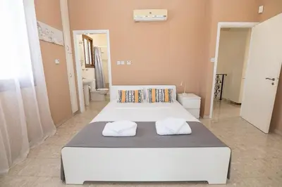 a large bedroom with two beds with towels on them at Malama 28 Villa Ekaterina in Paralimni