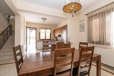 a kitchen and dining room with a wooden table and chairs at Malama 28 Villa Ekaterina in Paralimni