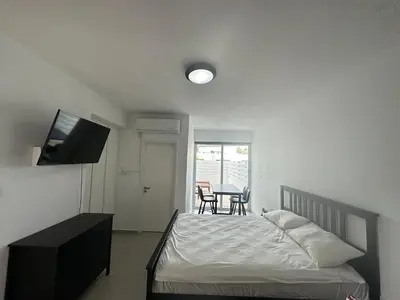 a bedroom with a bed and a television and a table at Dene Hollow Ayia Napa 2 in Ayia Napa