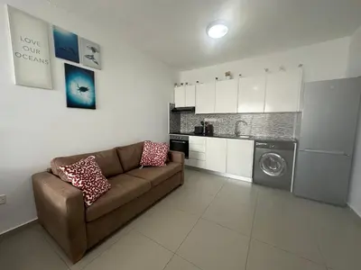 a living room with a couch and a washing machine at Dene Hollow Ayia Napa 2 in Ayia Napa