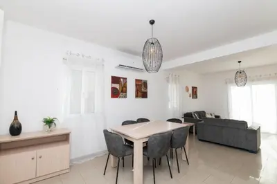 a living room with a table and a couch at Pernera Gardens Villa Ekaterina in Protaras