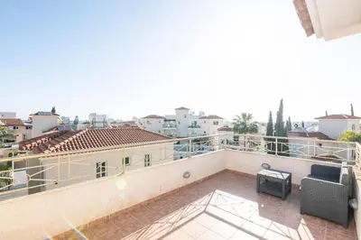 a balcony with a couch and a view of a city at Pernera Gardens Villa Ekaterina in Protaras