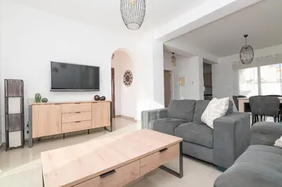 a living room with a couch and a tv at Pernera Gardens Villa Ekaterina in Protaras