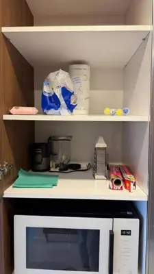 a kitchen cabinet with a shelf with a microwave at Luxury Apartments with Sea View and Mountain View in Grand Sapphire Resort in Iskele
