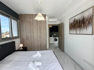 a bedroom with a white bed with towels on it at New 1 bedroom flat in Aglatzia in Aglantzia