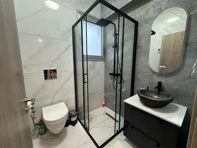 a bathroom with a sink and a toilet and a mirror at New 1 bedroom flat in Aglatzia in Aglantzia