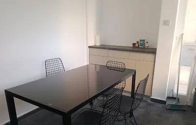 a table and chairs in a room with a kitchen at alfarome60 in Nicosia