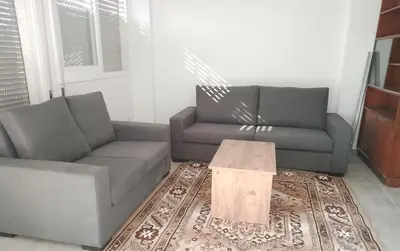 a living room with two couches and a wooden table at alfarome60 in Nicosia