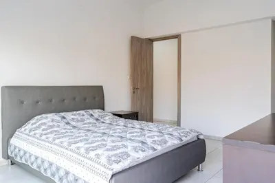 a bedroom with a bed in a white room at Penthouse with outdoor hottub in Limassol