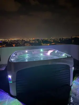 a hot tub on the roof of a building at night at Penthouse with outdoor hottub in Limassol