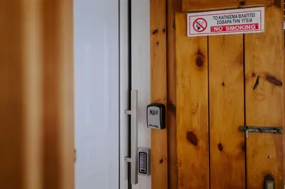 a wooden door with a no smoking sign on it at Stylish Stonehouse in Platres in Platres