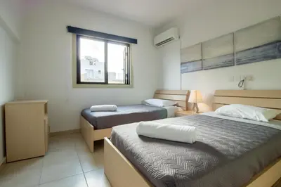 a bedroom with two beds and a window at Large Veranda 2BR Walk to Beach in Paralimni