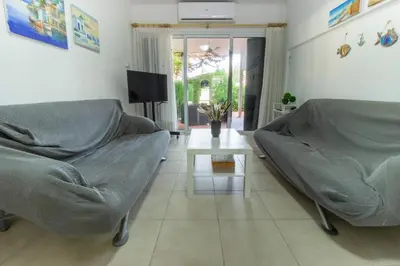 a living room with a couch and a table at Large Veranda 2BR Walk to Beach in Paralimni