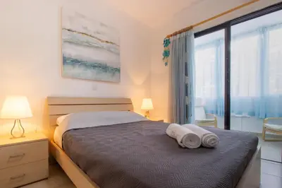 a bedroom with a bed with two towels on it at Large Veranda 2BR Walk to Beach in Paralimni