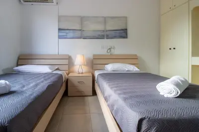 a bedroom with two beds and a lamp on a night stand at Large Veranda 2BR Walk to Beach in Paralimni