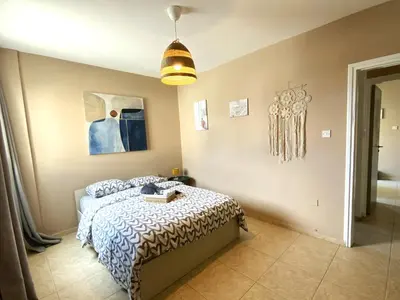 a bedroom with a bed and a lamp at 2Br Apt - 5mins walk to the Beach with Internet access in Larnaka