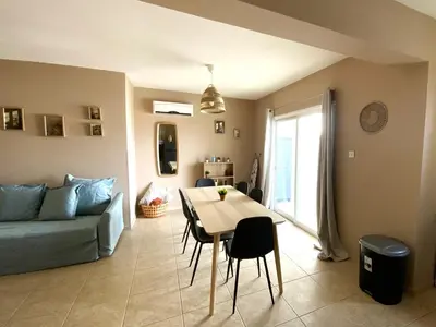 a living room with a table and a blue couch at 2Br Apt - 5mins walk to the Beach with Internet access in Larnaka