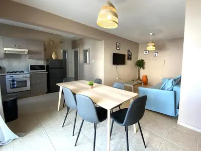 a kitchen and dining room with a table and chairs at 2Br Apt - 5mins walk to the Beach with Internet access in Larnaka