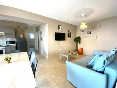 a living room with a blue couch and a table at 2Br Apt - 5mins walk to the Beach with Internet access in Larnaka