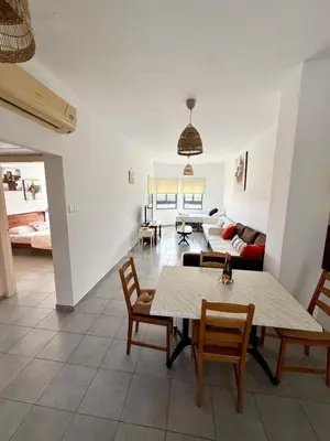 a living room with a table and chairs and a couch at Elena One Bedroom Budget Apt - License no 06991 in Paralimni