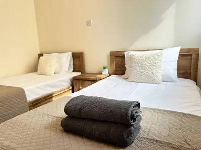 a bedroom with two beds with towels on the floor at Serenity Sunset Holiday Apt - Larnaca in Larnaka