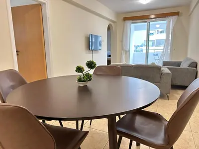 a living room with a table and chairs at Serenity Sunset Holiday Apt - Larnaca in Larnaka
