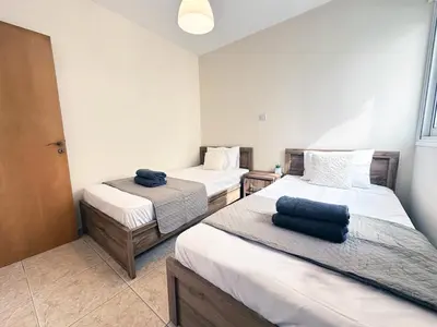 a room with two beds and two towels at Serenity Sunset Holiday Apt - Larnaca in Larnaka