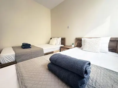 a bedroom with two beds and a blue towel on the floor at Serenity Sunset Holiday Apt - Larnaca in Larnaka