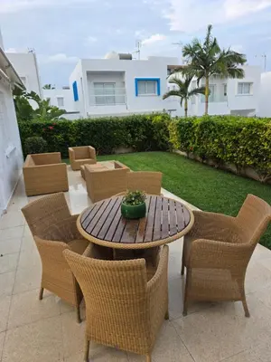 a patio with a table and wicker chairs at SWeET LEMON VILLA in Protaras