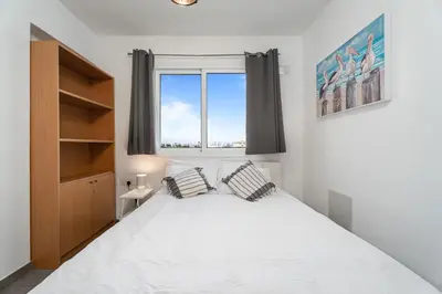 a bedroom with a large white bed and a window at Cyprus Sun in Paralimni