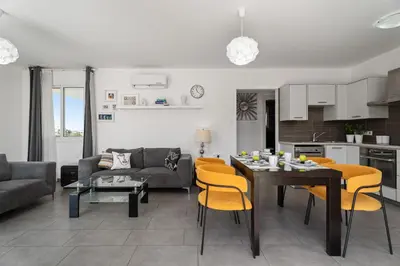 a living room with a couch and a table and chairs at Cyprus Sun in Paralimni