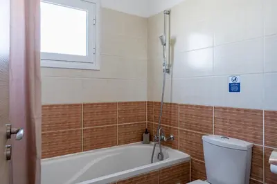a bathroom with a bath tub and a toilet at Olympus 2-Bedroom Apartment in Larnaka