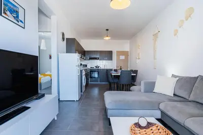 a living room with a couch and a kitchen at Olympus 2-Bedroom Apartment in Larnaka