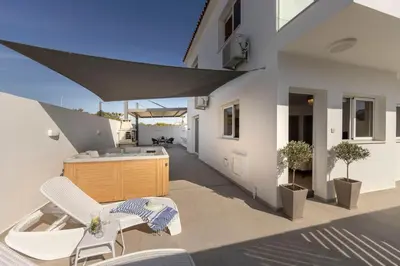 a patio with two white chairs and a tub at Villa Antonieta in Ayia Napa