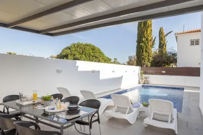 a patio with a table and chairs next to a swimming pool at Villa Antonieta in Ayia Napa