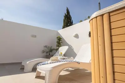 a pair of white chairs on a balcony at Villa Antonieta in Ayia Napa
