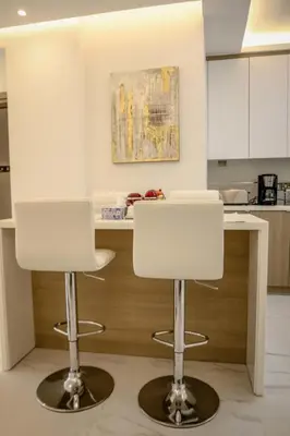 two white bar stools in front of a kitchen counter at Seaway moments in Limassol