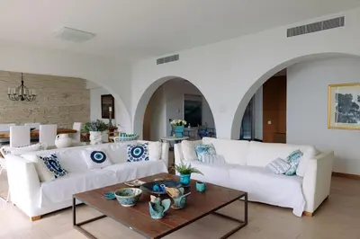 a living room with white couches and a table at 3BR Beachfront Gem in Limassol in Limassol