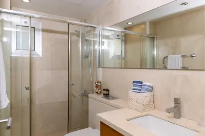 a bathroom with a shower and a sink and a mirror at 3BR Beachfront Gem in Limassol in Limassol