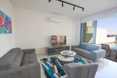 a living room with a couch and chairs and a tv at Protaras Aqua Pearl Villa AQ12 in Paralimni