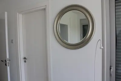 a round mirror on a white door in a bathroom at Marymina Villa in Protaras