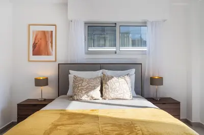 a bedroom with a large bed with two windows at Elegant City Central Suite in Nicosia