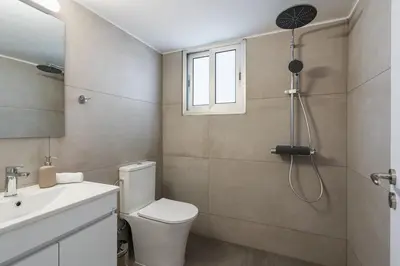 a bathroom with a toilet and a sink and a shower at Elegant City Central Suite in Nicosia