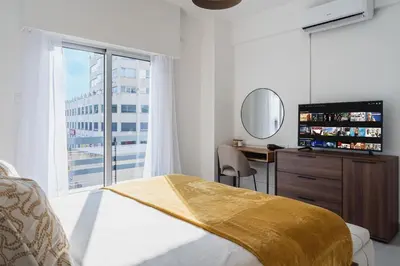 a bedroom with a bed and a television and a window at Elegant City Central Suite in Nicosia