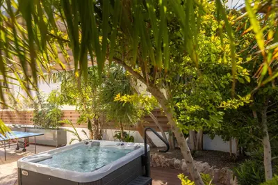 a hot tub sitting next to a palm tree at Villa Protaras View 9 Central Protaras -Fig Tree Bay-Jacuzzi-Hot Tub in Protaras